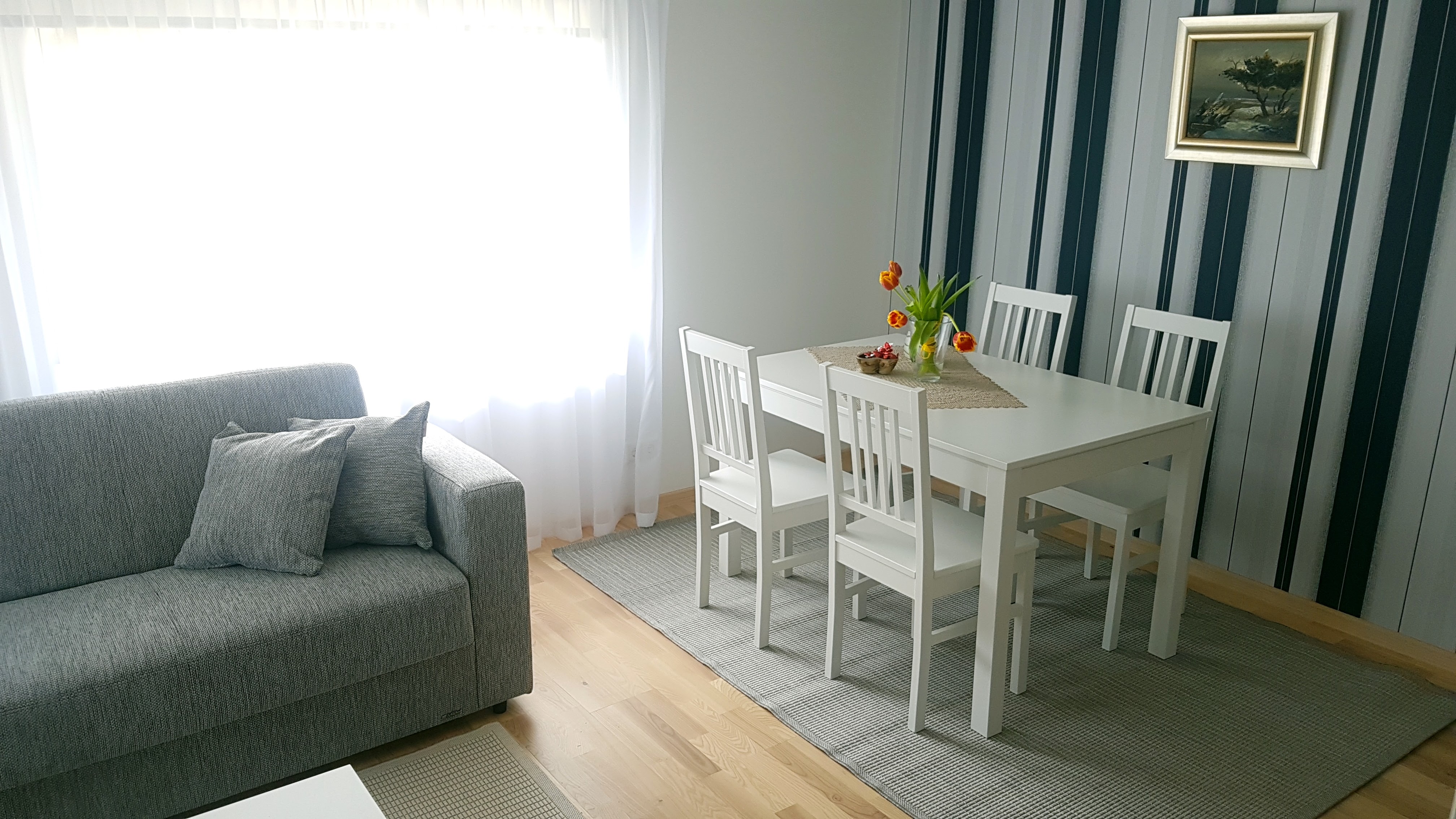 Söögitoa valge laud ja hall diivan